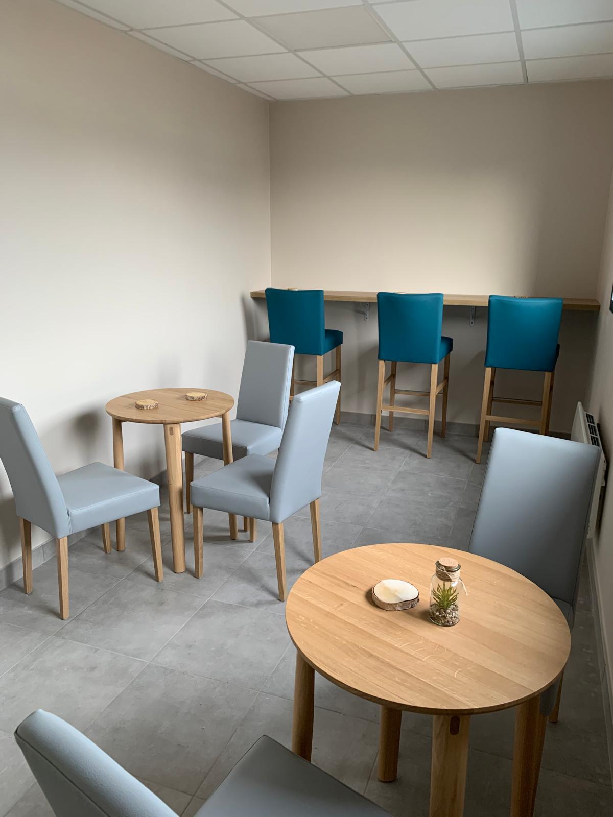 Salle avec tables et chaises modernes.